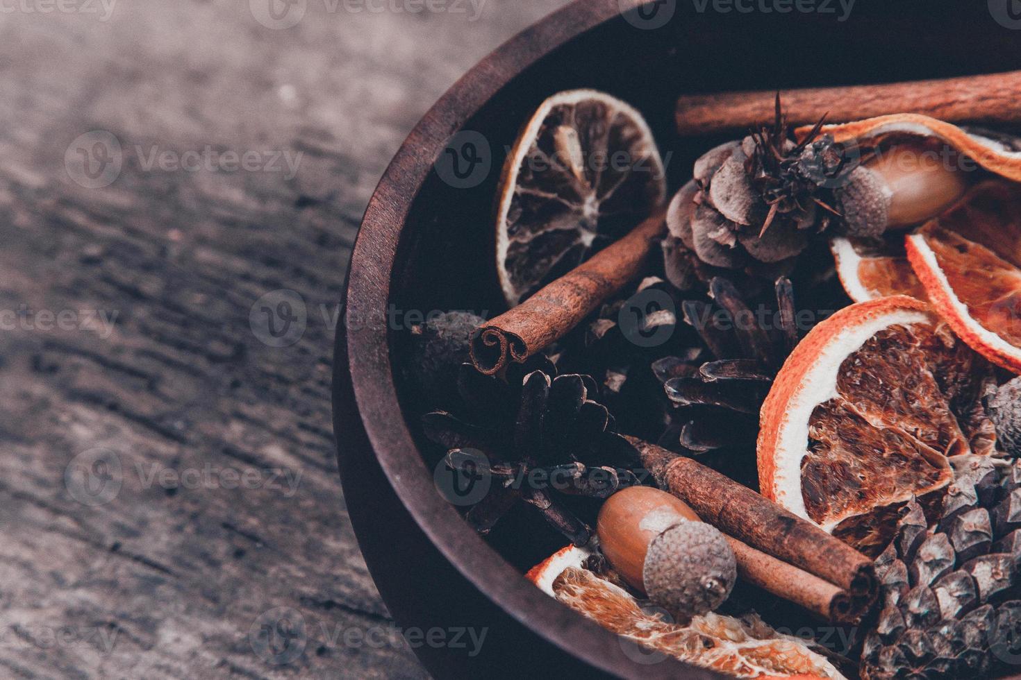 Tangerines, cones and spices on a wooden background photo