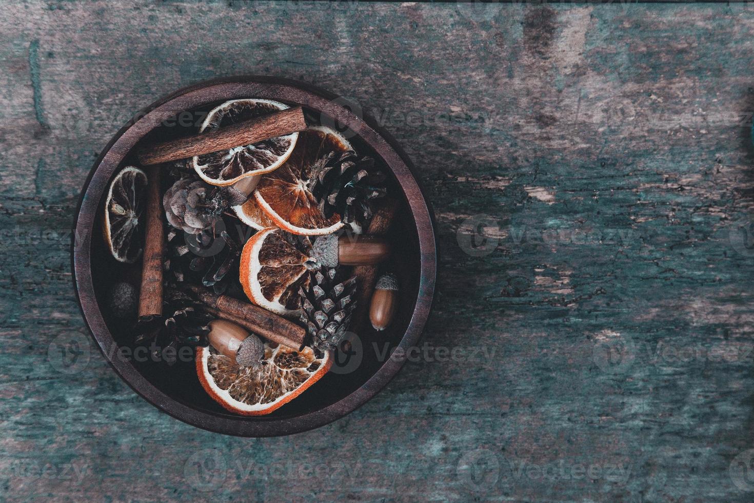Tangerines, cones and spices on a wooden background photo