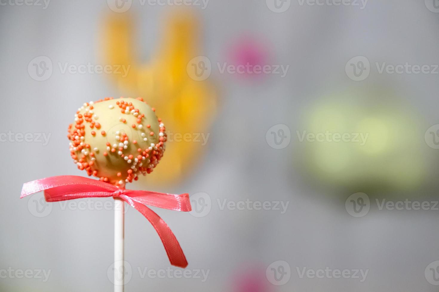 White chocolate cake pop decorated with colorful confectionery sprinkles photo