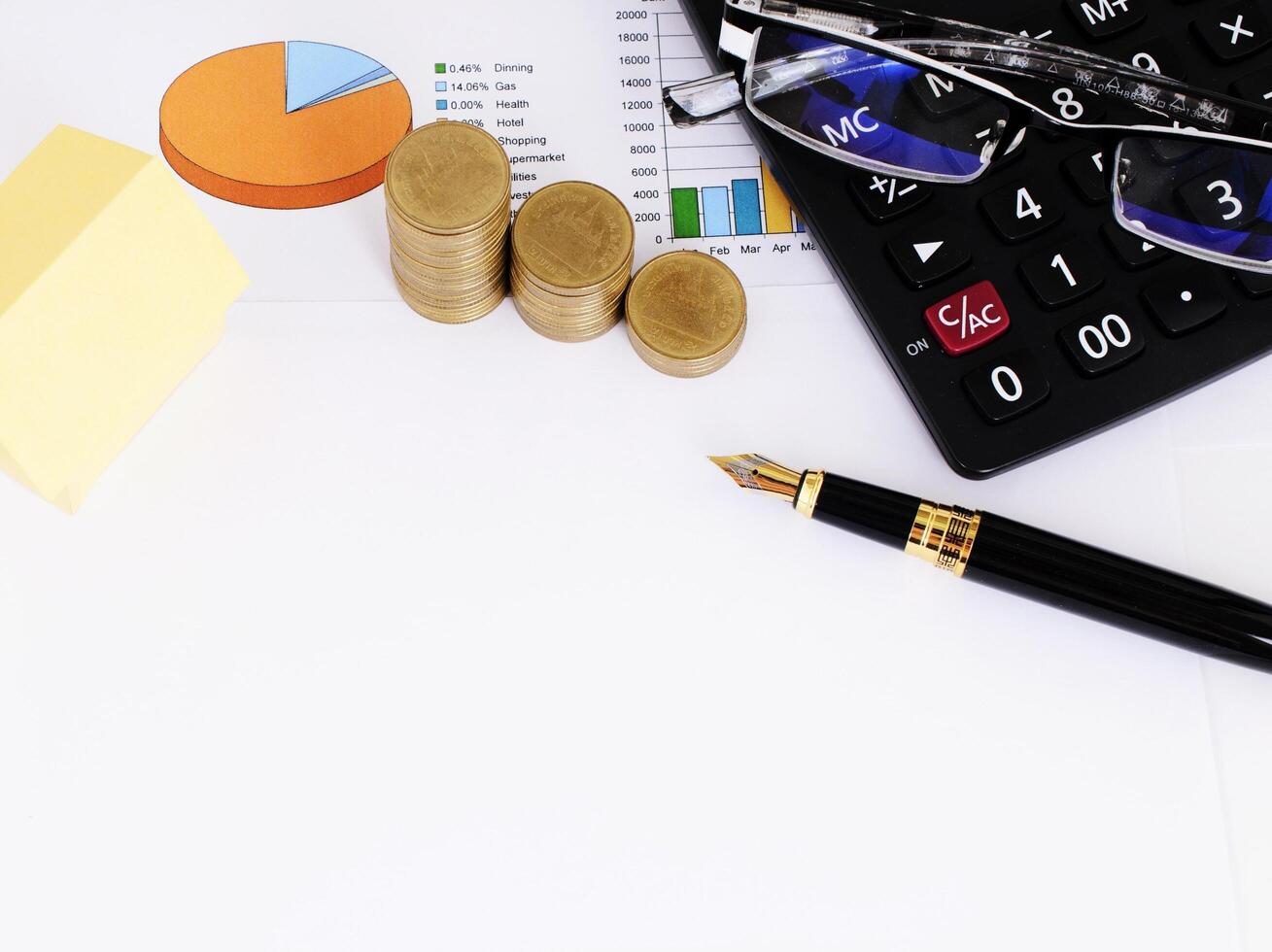 Mortgage loans concept with yellow paper and funtain pen and coins and calculator and eyeglasses photo