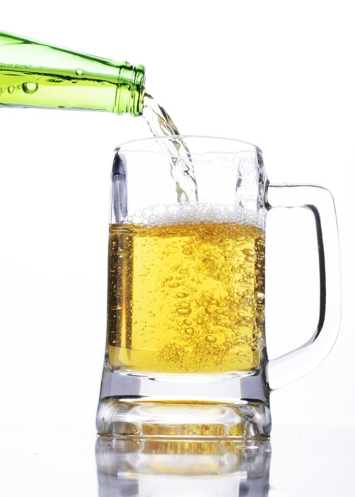 Celebrate beer days concept with pouring beer into a glass on white background photo