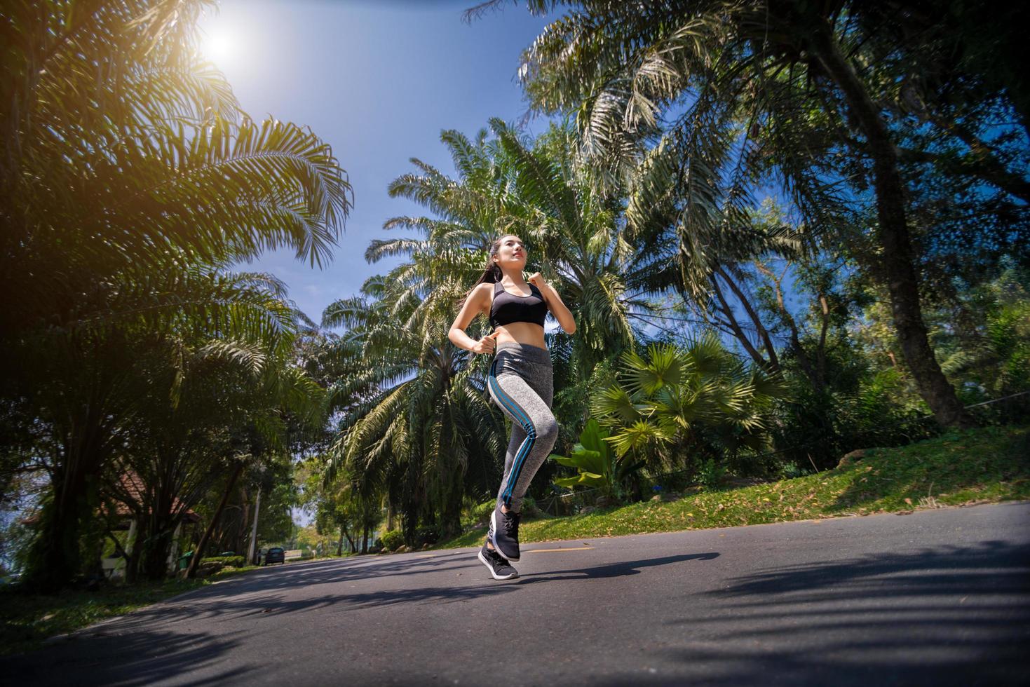 Pretty woman jogging in the park, running outdoors in nature photo
