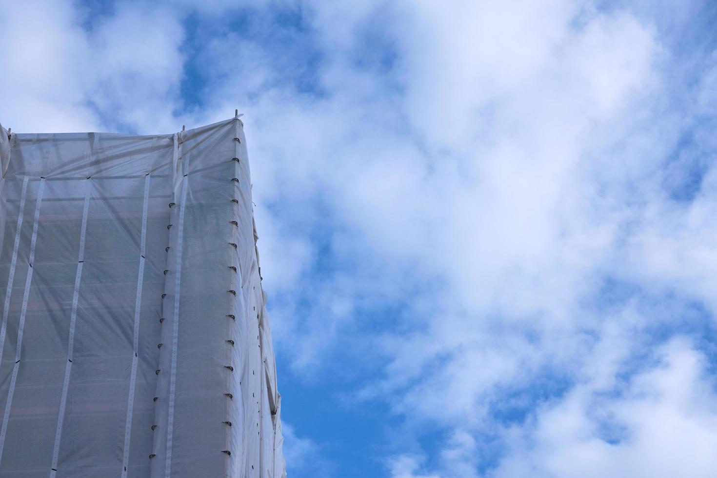 Construction scaffolding against a blue sky with white clouds photo