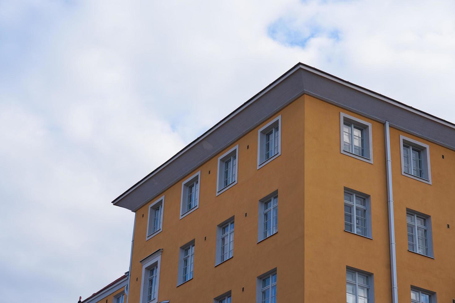 Orange high rise building against the white clouds photo