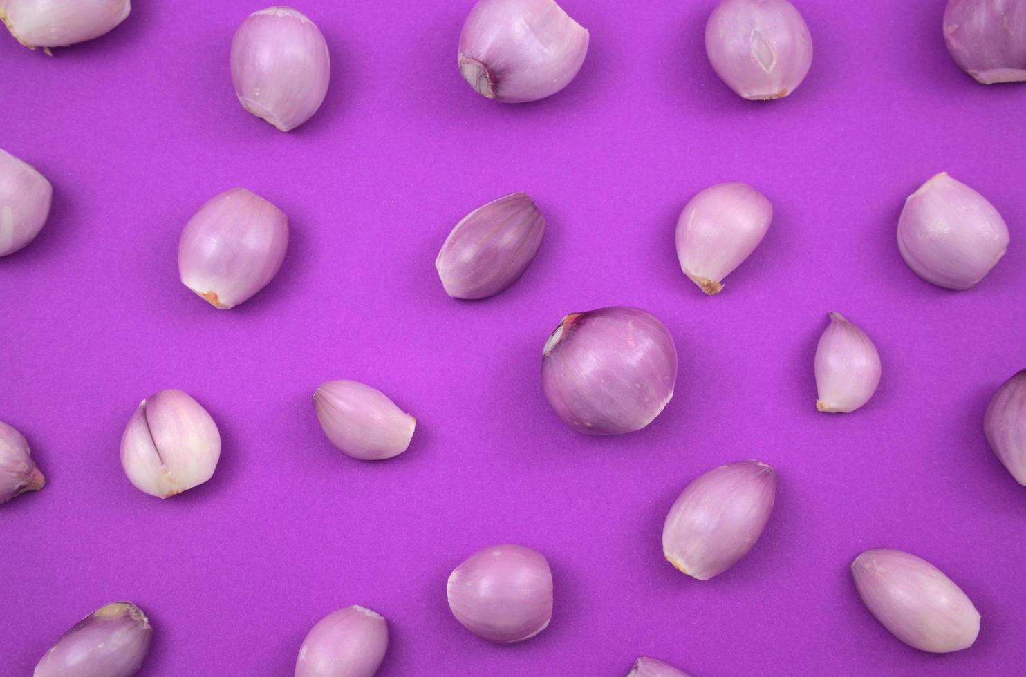 Fresh peeling onions flat lay on purple background photo