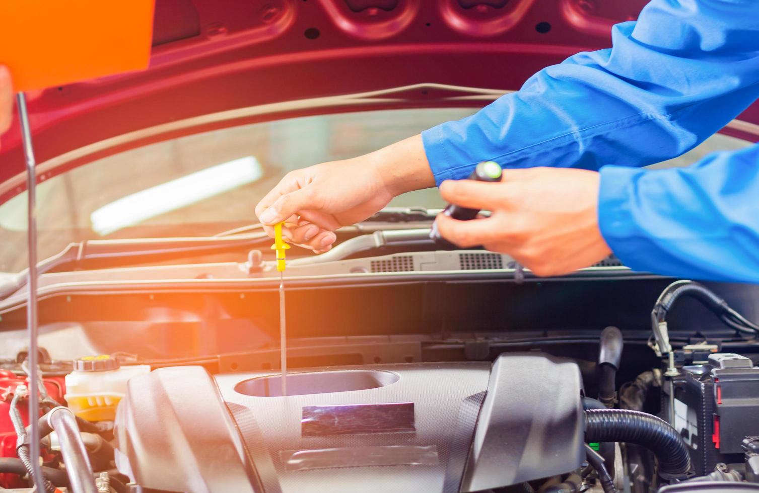 Mechanics in the automotive service department are checking the condition of the engine and changing the oil photo