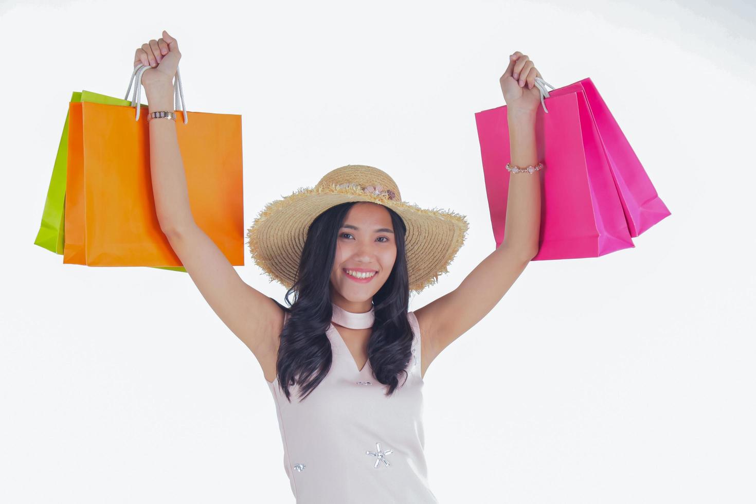 Mujer asiática llevando bolsas de la compra con caras sonrientes sobre un fondo blanco. foto