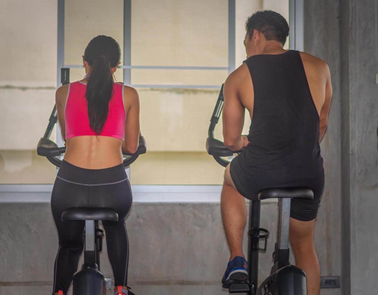 Hermosa mujer asiática está haciendo ejercicio en un gimnasio con un entrenador personal foto