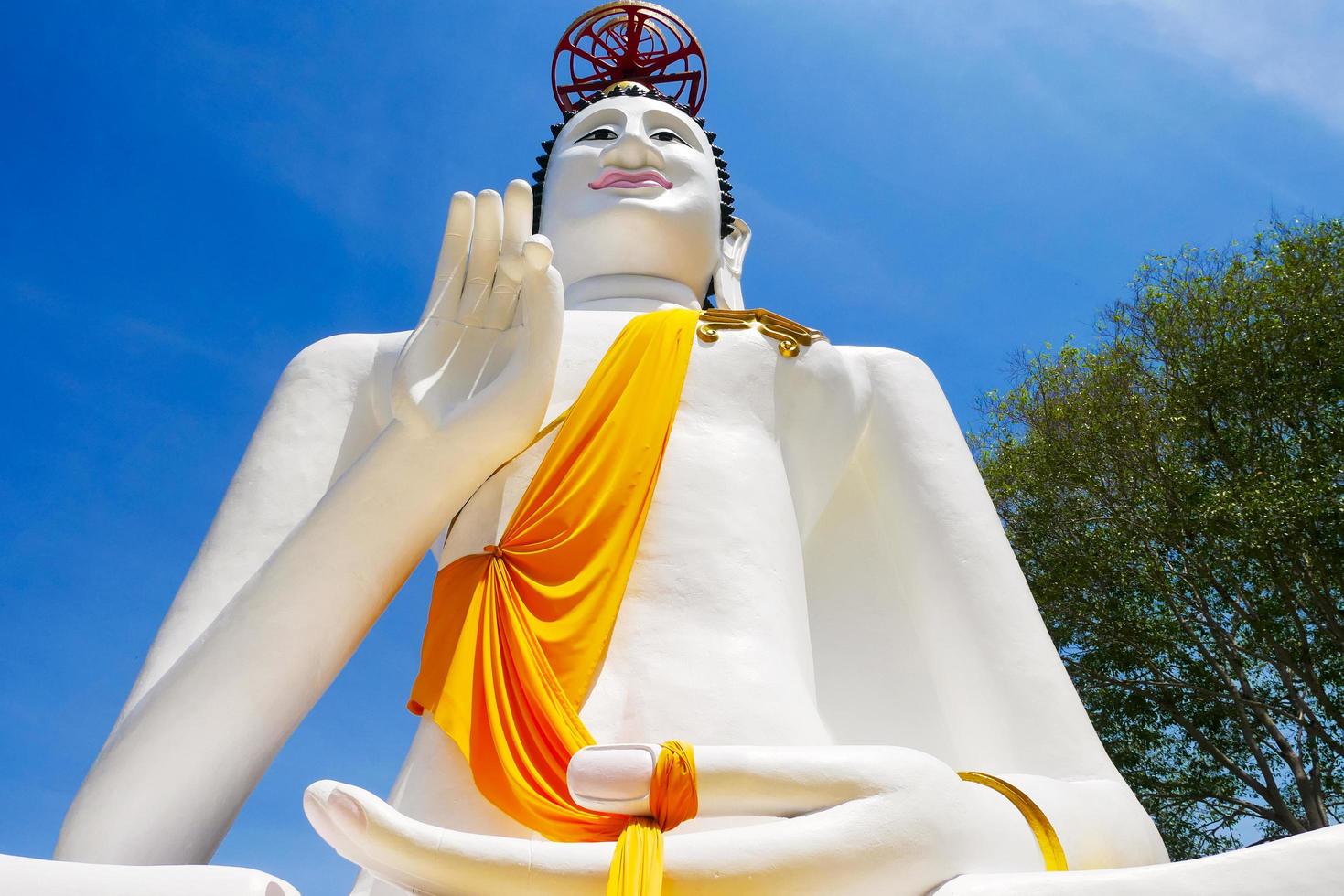 Gran estatua de Buda blanco sobre un fondo de cielo azul foto