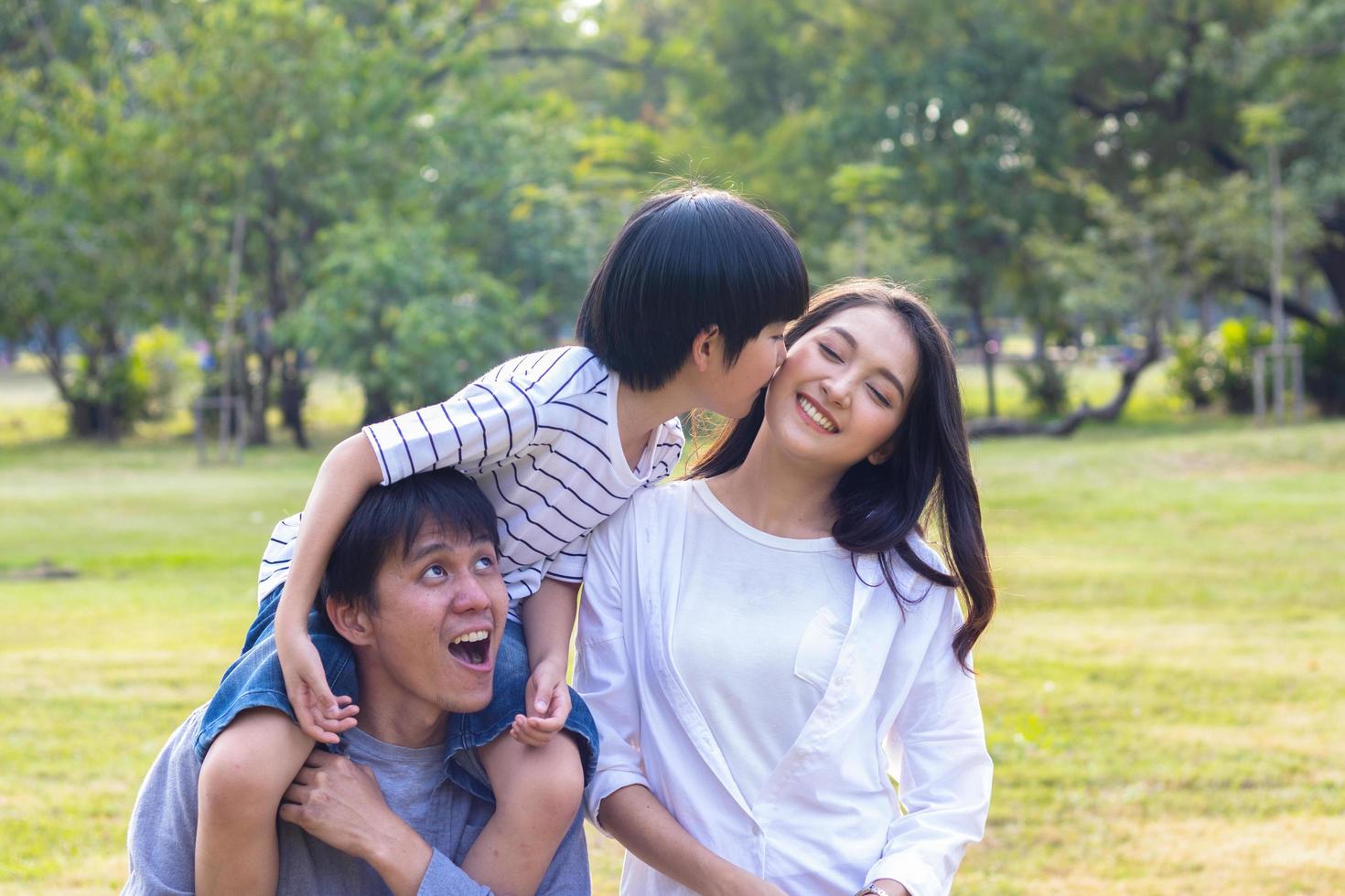 familia asiática disfruta de sentarse en el parque en las vacaciones de otoño foto