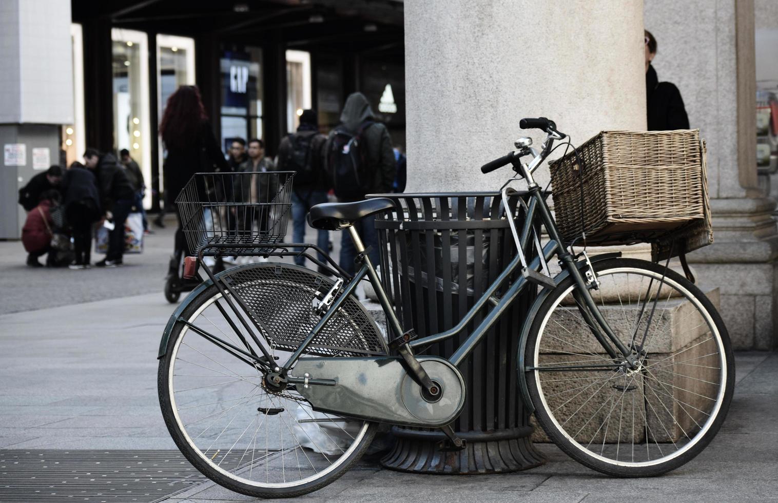 Blue city bike parked beside brown wooden bench photo