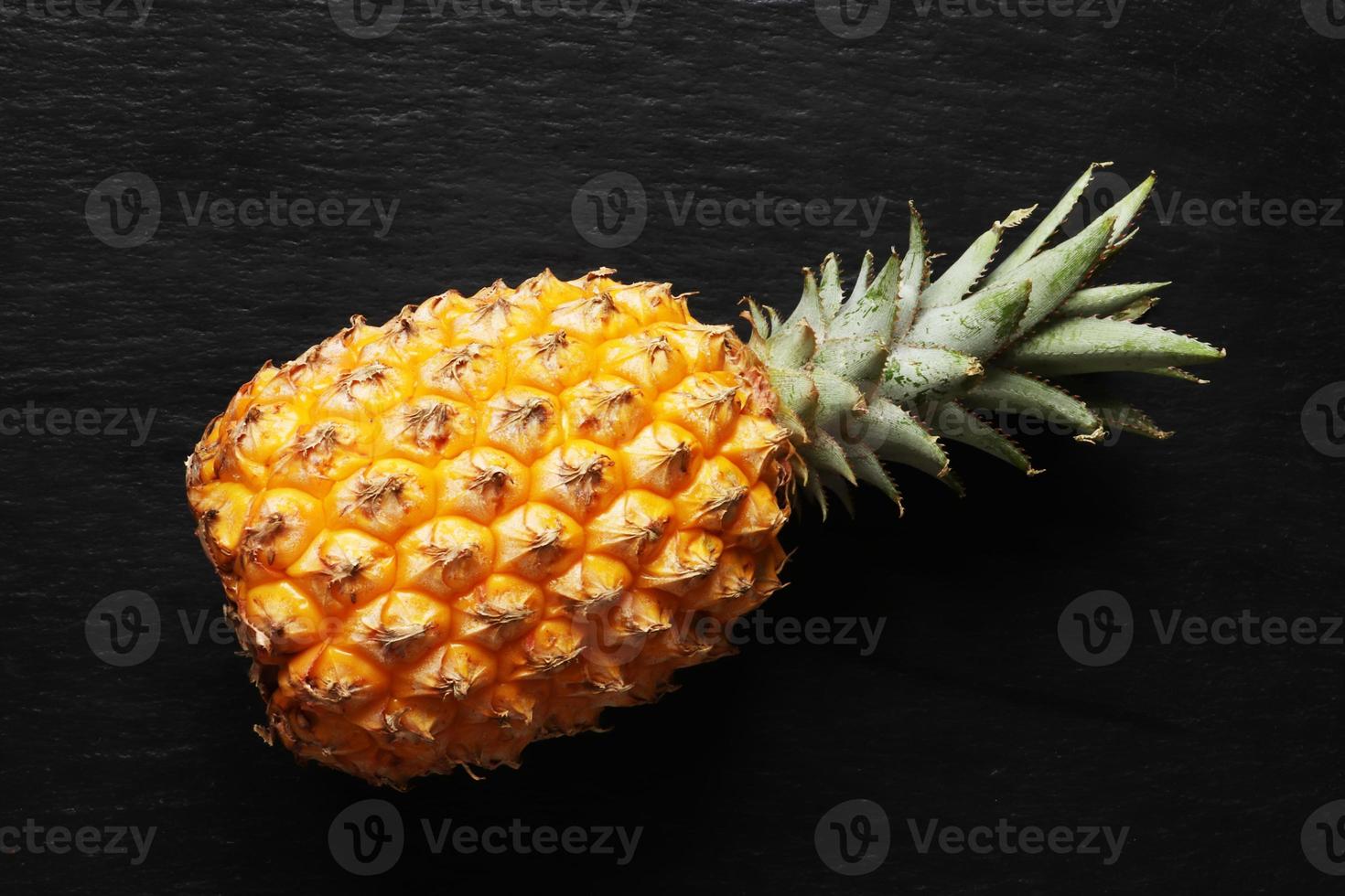 Fotografía de una piña victoria sobre un fondo de pizarra para la ilustración de alimentos foto