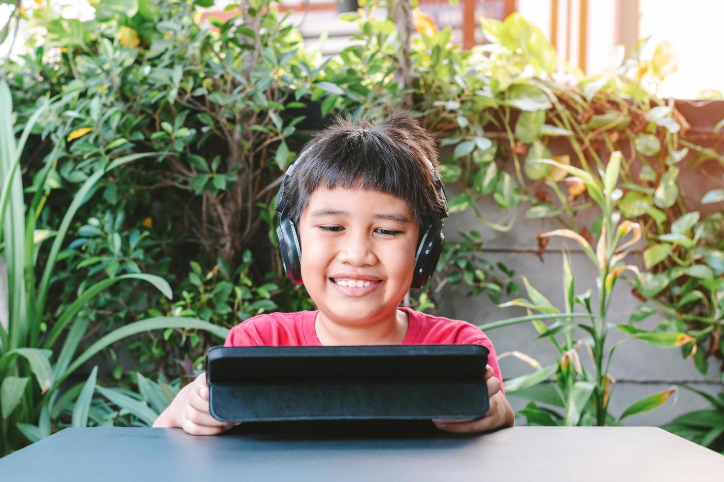 Asian cute boy playing games on the tablet photo