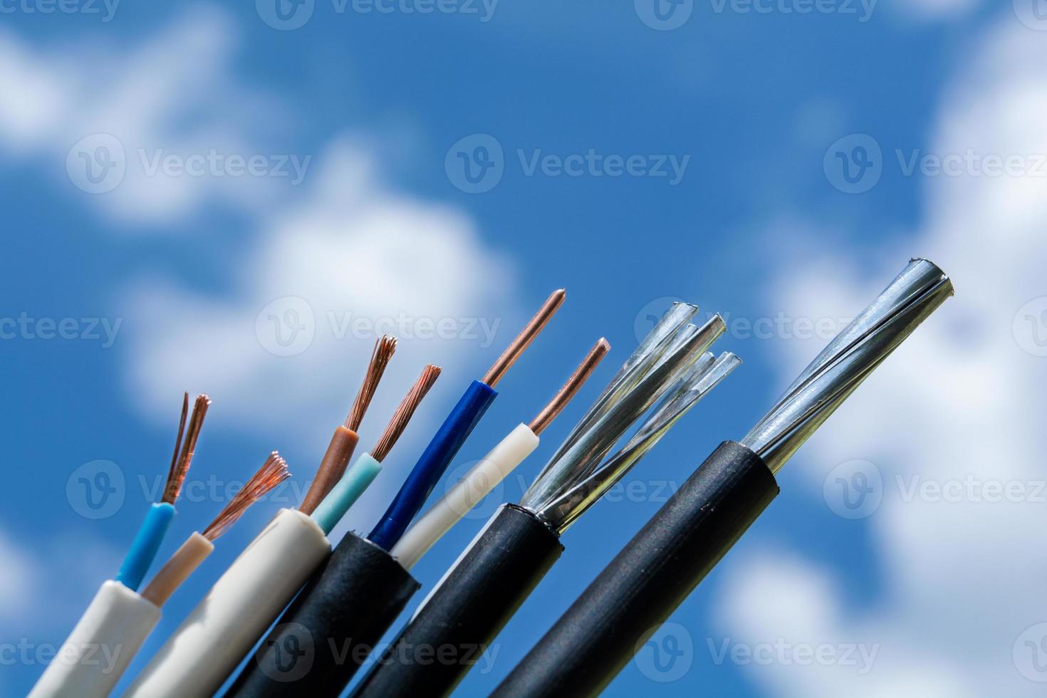 Varios cables pelados contra el cielo y las nubes. foto