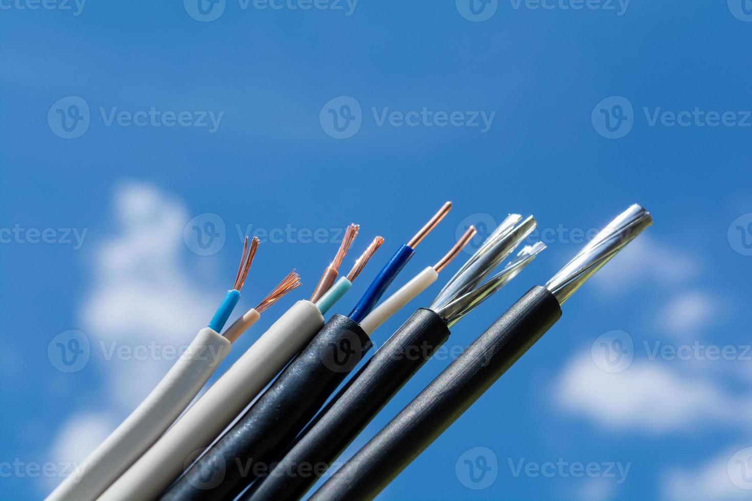 Varios cables pelados contra el cielo y las nubes. foto