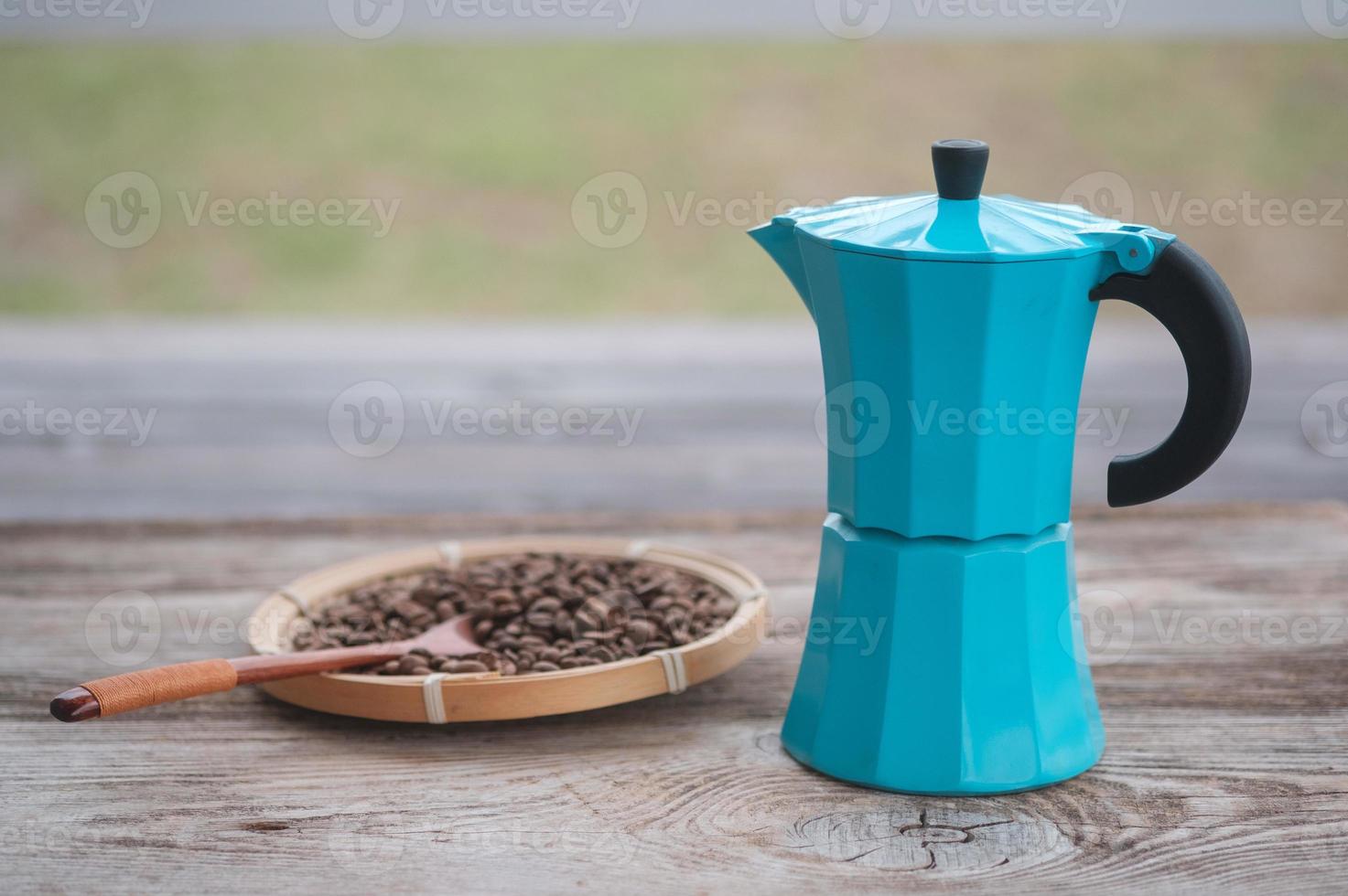 blue geyser coffee maker and roasted coffee beans on the background of an old wooden board photo