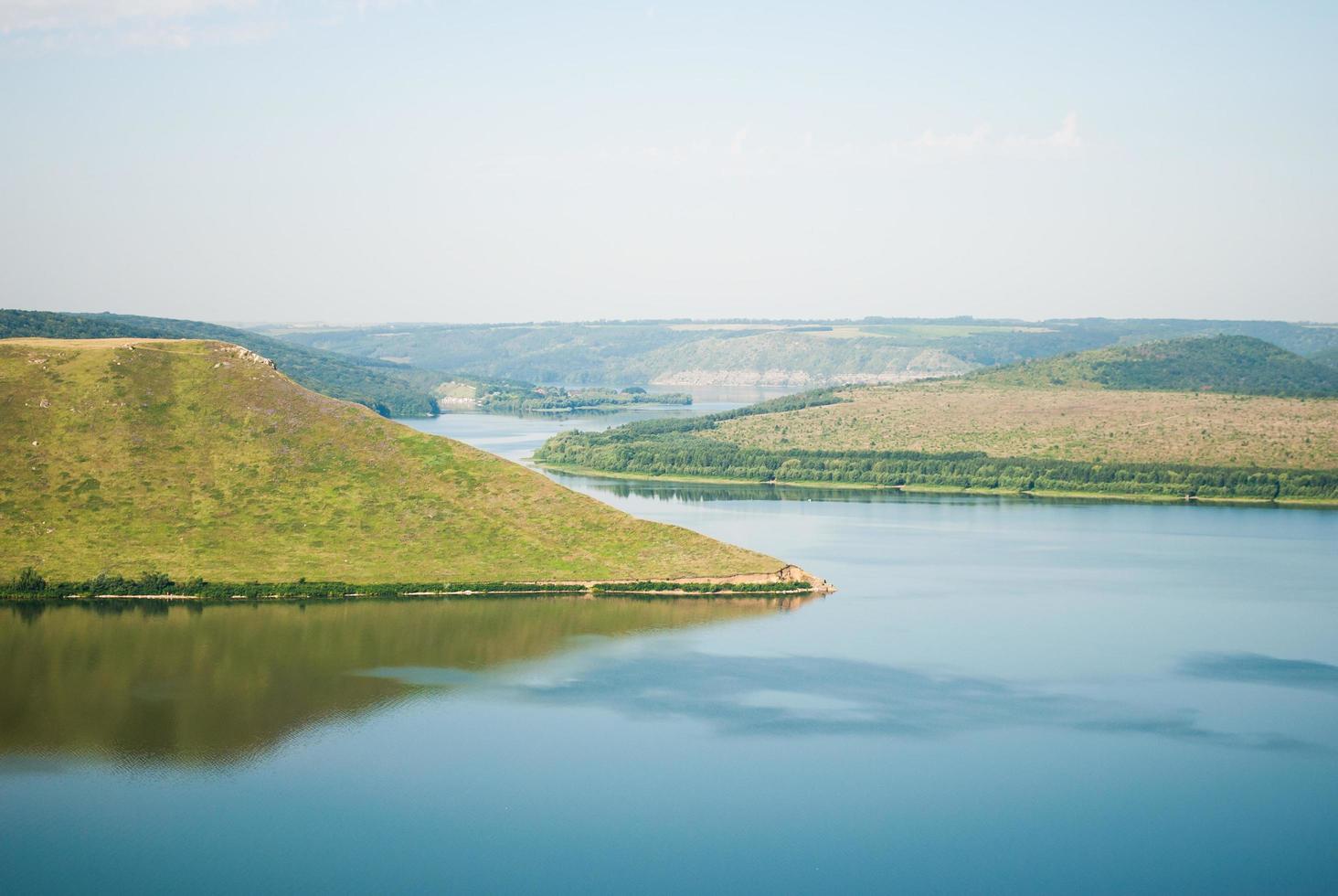 Bright and clear nature background with river and hills photo