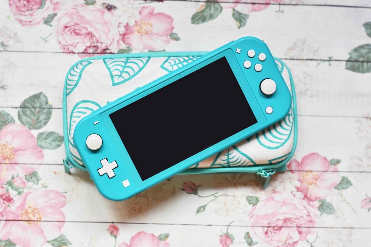 Portable Console Switch Lite with case on flower background photo