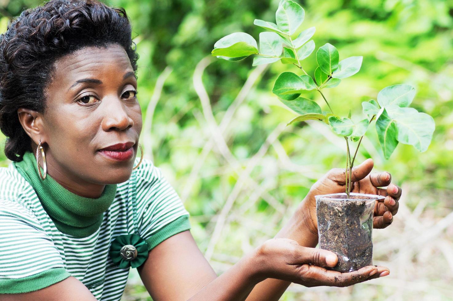 young woman with a flower planted in a bowl photo