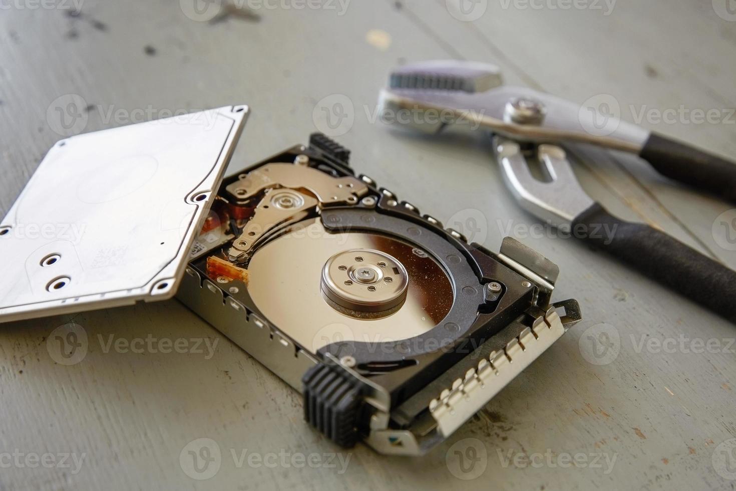 Broken and Destroyed Hard Drive Disk on Wooden Table photo