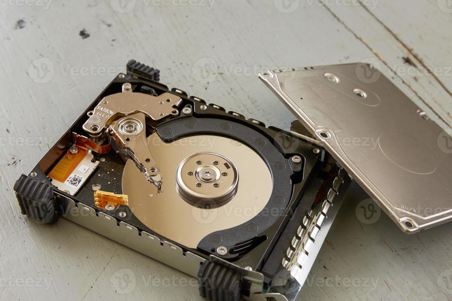 Close Up of Broken and Destroyed Hard Drive Disk on Wooden Table photo