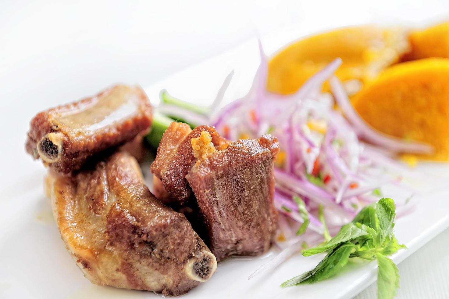 Comida tradicional peruana llamada chicharron de panceta de cerdo servida en un restaurante. foto