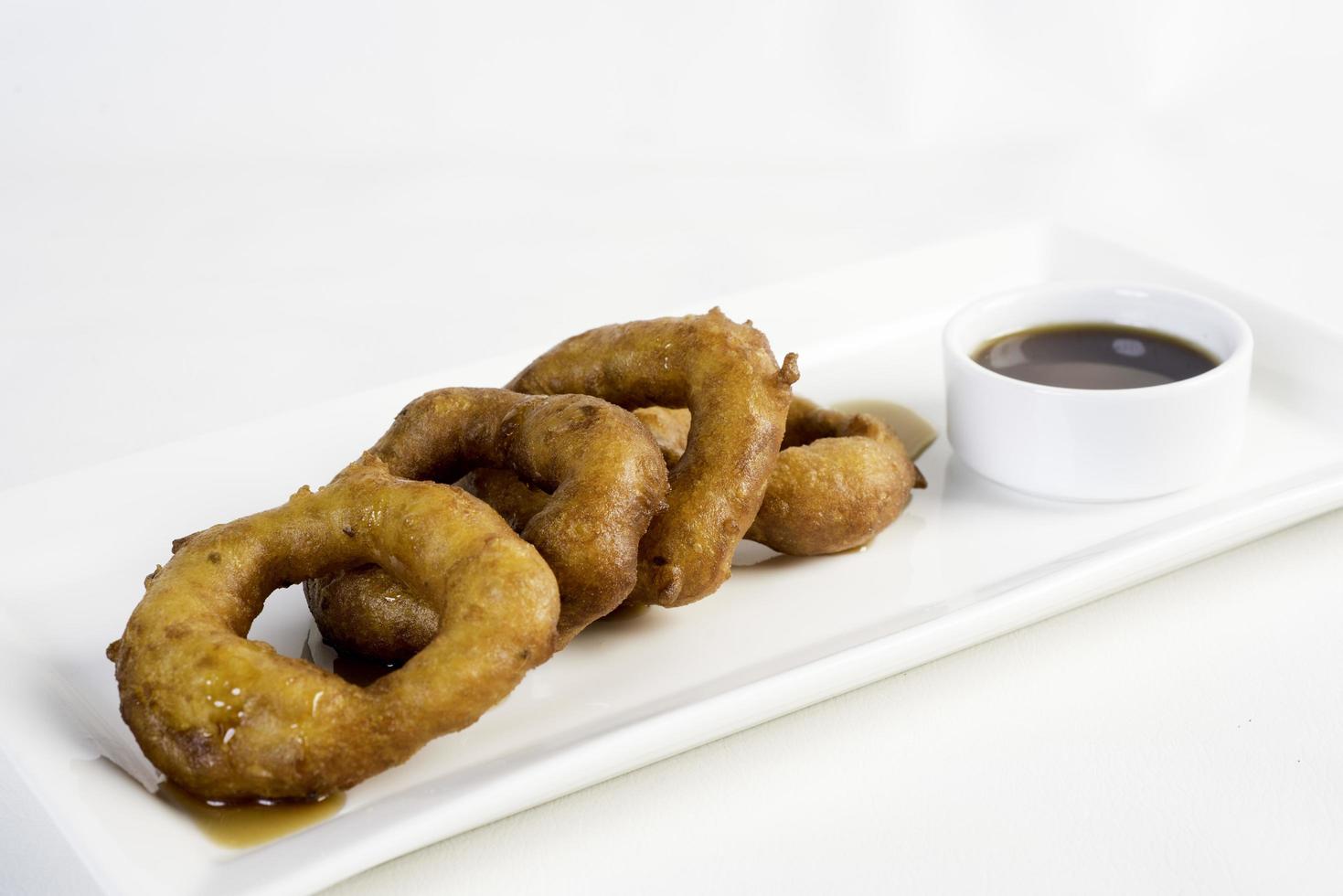 Picarones These are ring shaped dessert made with wheat flour dough mixed with pumpkin and sweet potato fried and dipped in fig molasses photo