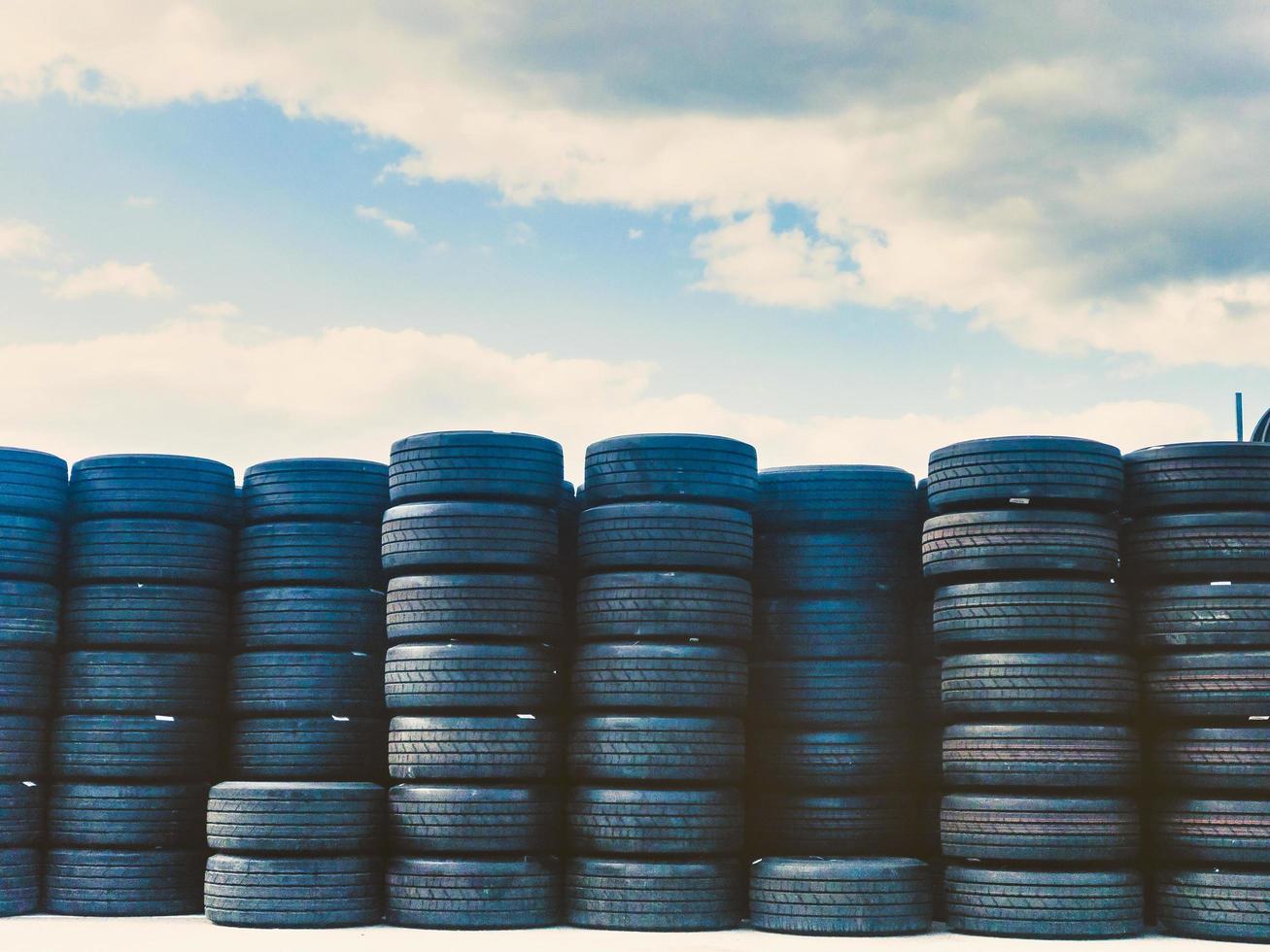 Many stacked old orry tyres on display photo