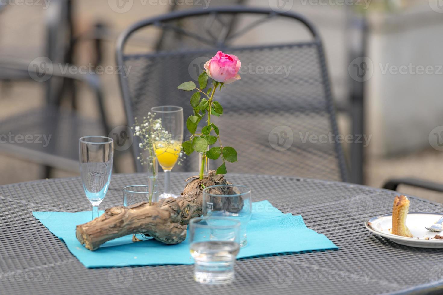 After the party  flowers decoration with used glasses and plates stands on a patio table photo