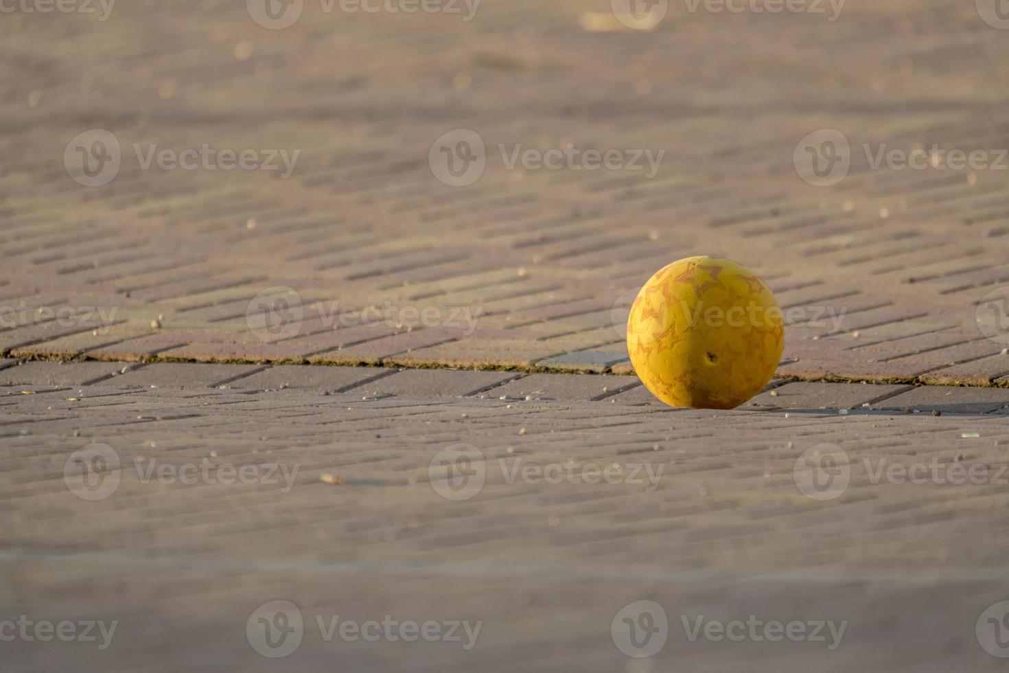 Yellow Kids Ball Lies on a Paved Place photo