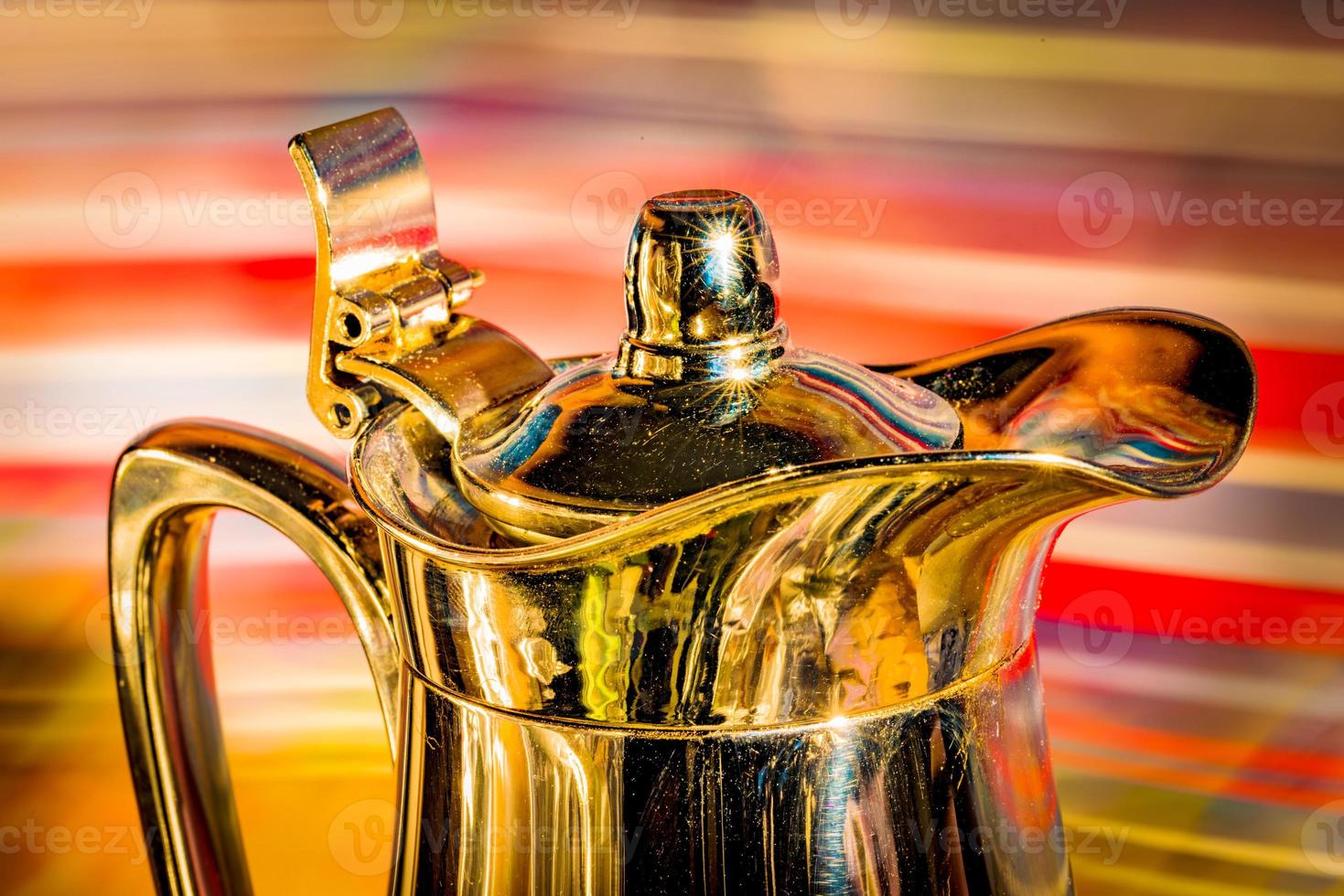 Shiny coffee pot in front of colorful background photo