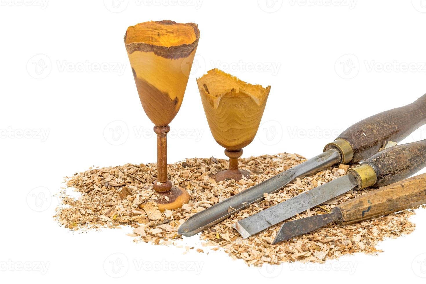 Hand turned wooden goblets decorated with sawdust and tool isolated on white photo