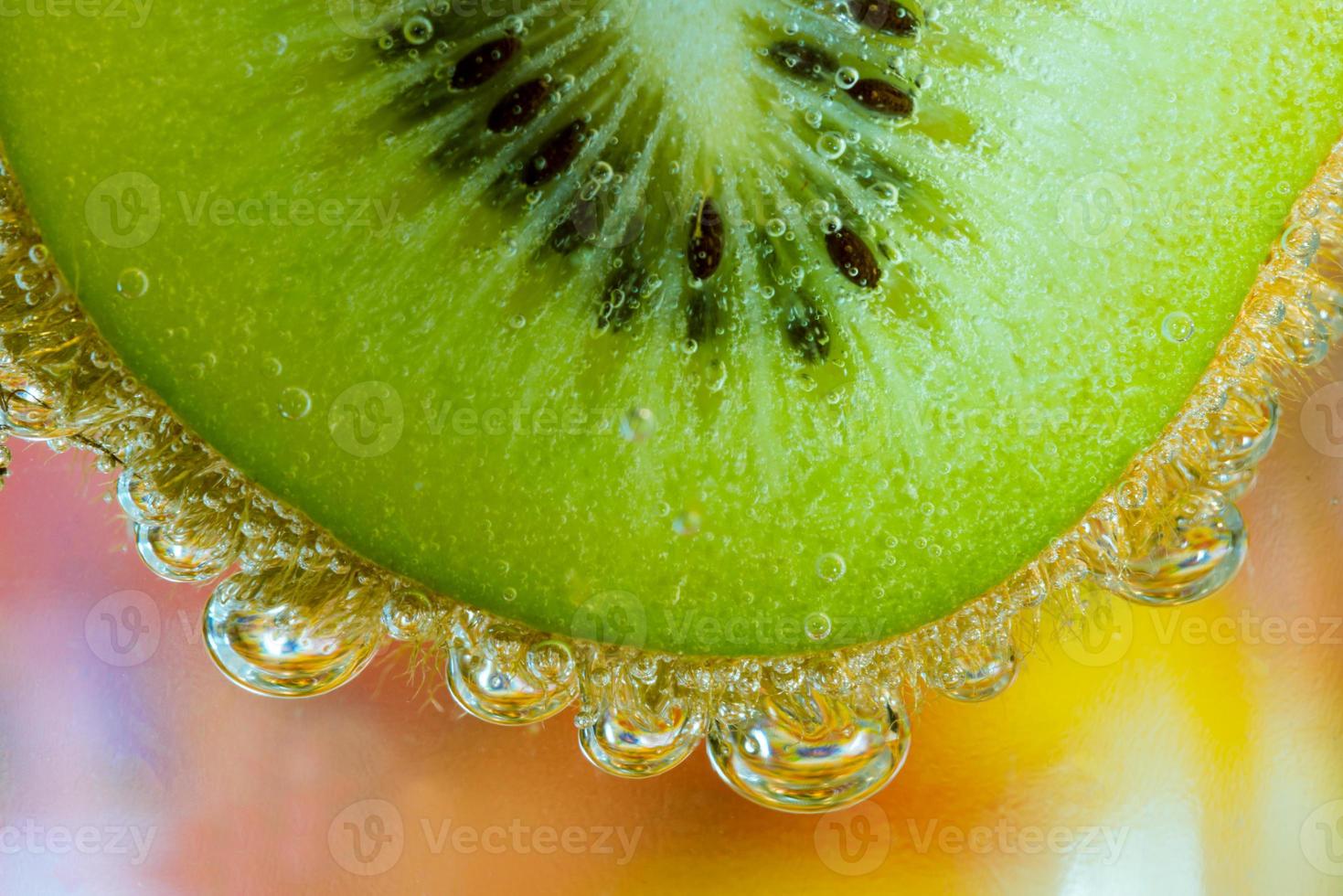 Kiwi in the water with air beads in front of colorful background photo