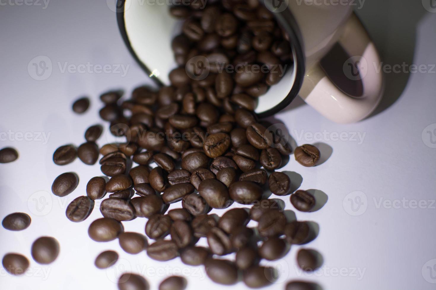 Roasted beans  and cup on white background photo