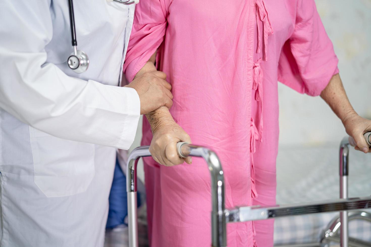 Asian senior or elderly old lady woman patient walk with walker at nursing hospital ward photo