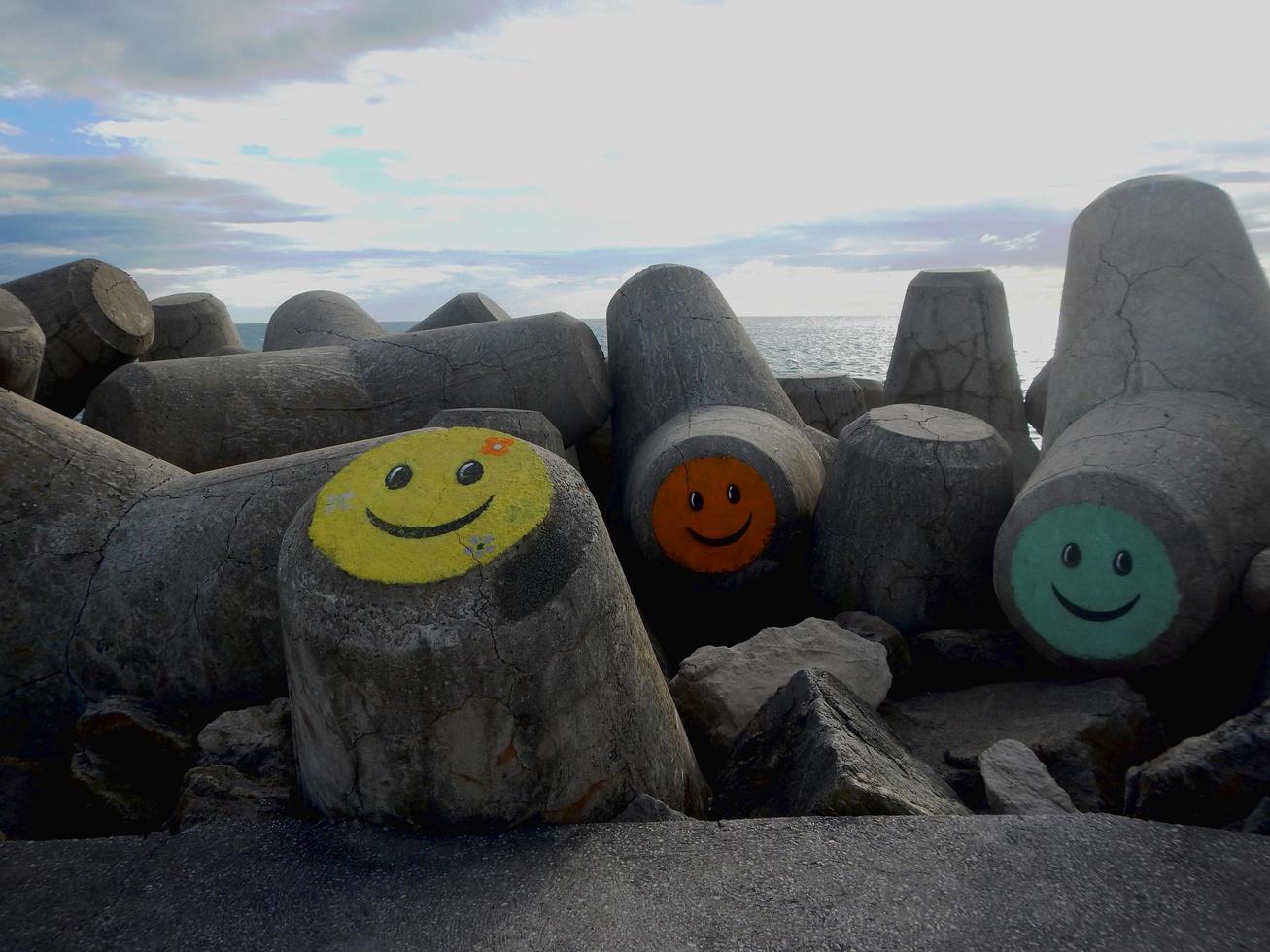 City, Country, MM DD, YYYY - Concrete blocks with colored faces on the beach shore photo