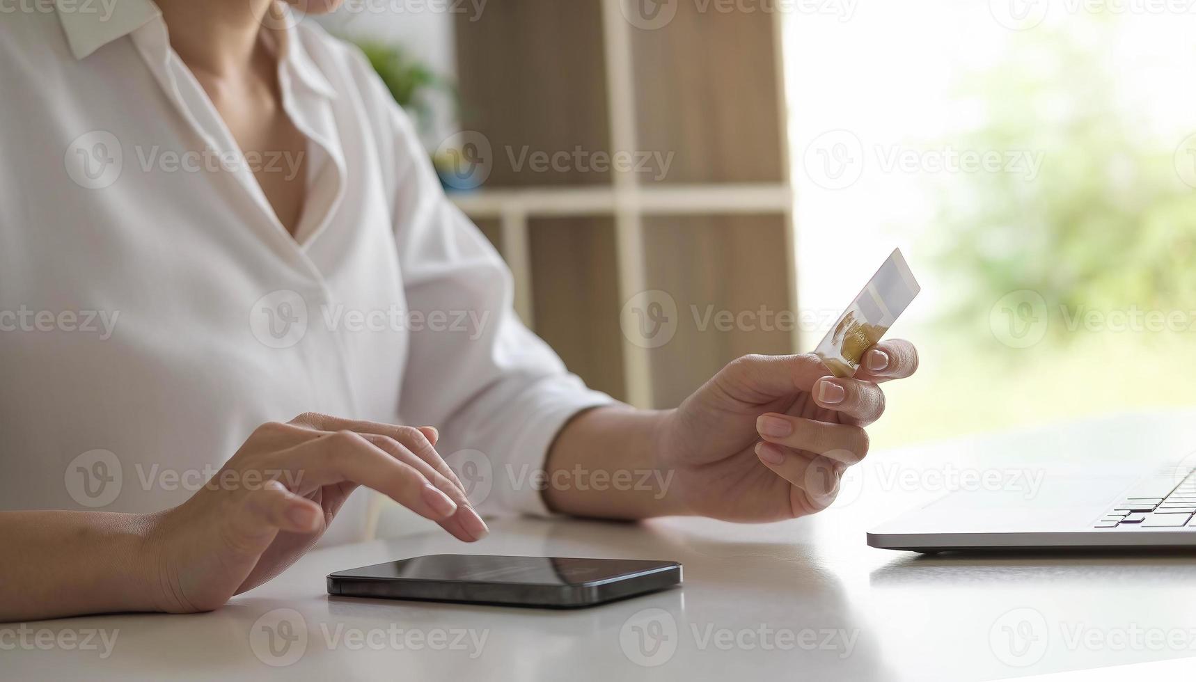 Mujer joven con tarjeta de crédito y uso de teléfonos inteligentes para compras en línea concepto de compras de pago en línea foto