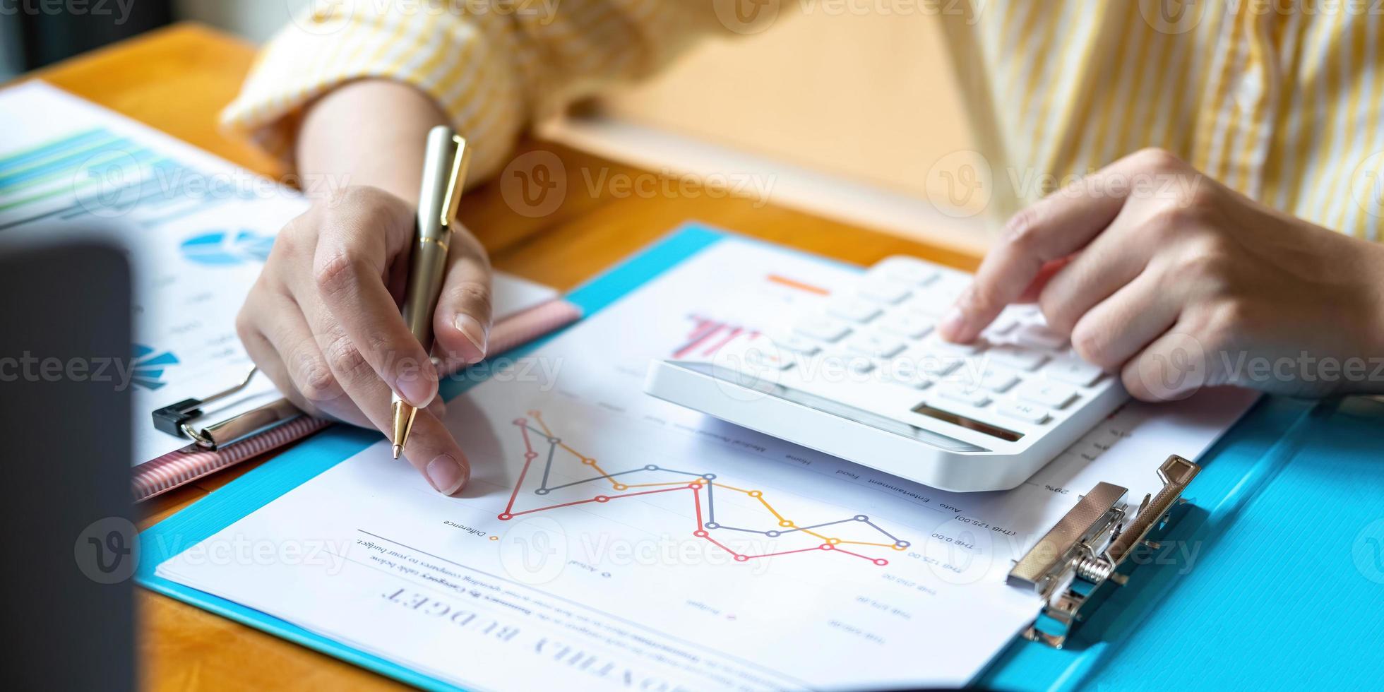 Mujer de negocios con calculadora y computadora portátil para hacer finanzas matemáticas en un escritorio de madera en la oficina y antecedentes de trabajo empresarial estadísticas de contabilidad fiscal y concepto de investigación analítica foto