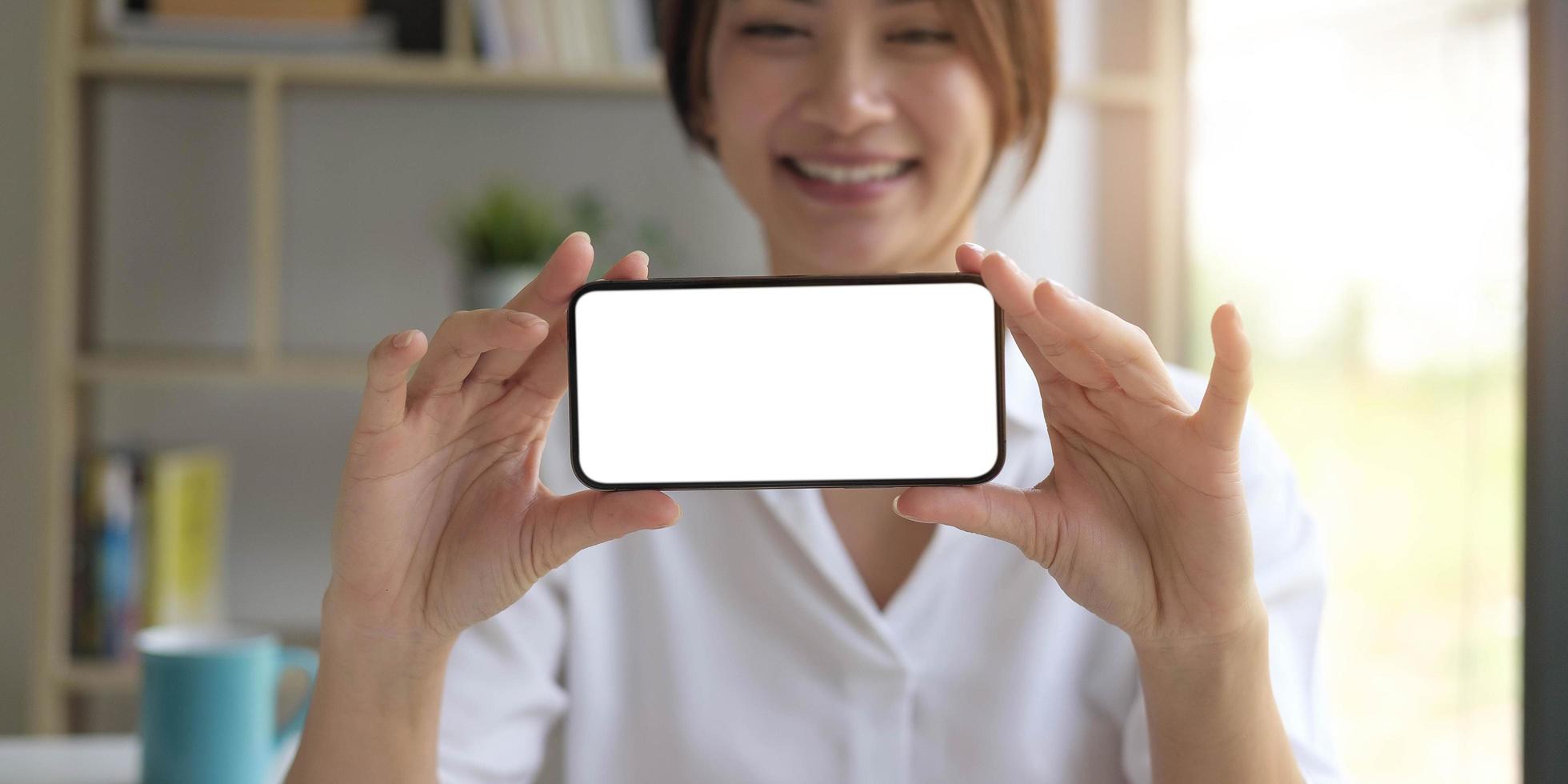 Mockup image of a beautiful woman hold a mobile phone with blank white screen photo