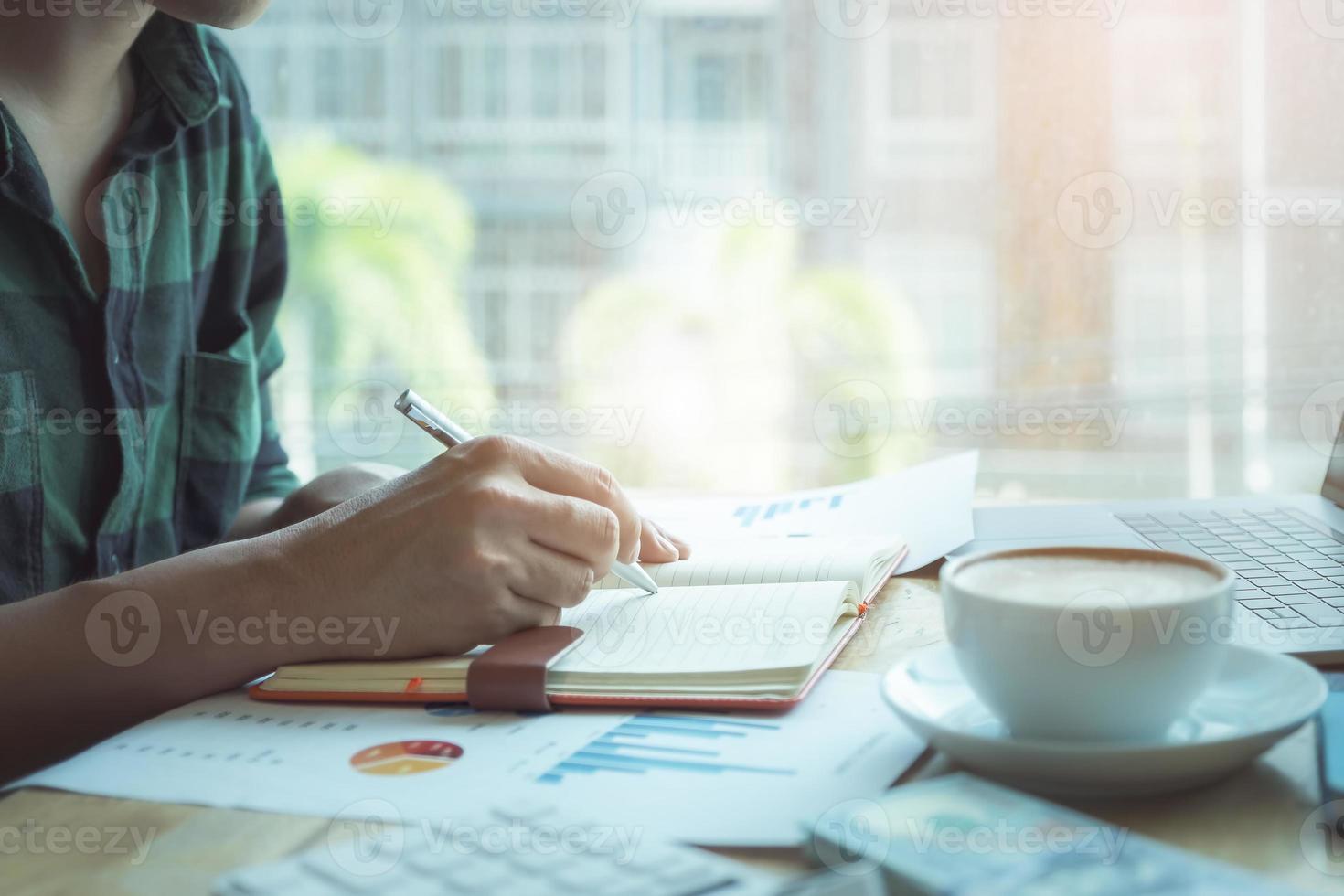 Accountant using pen to note data photo