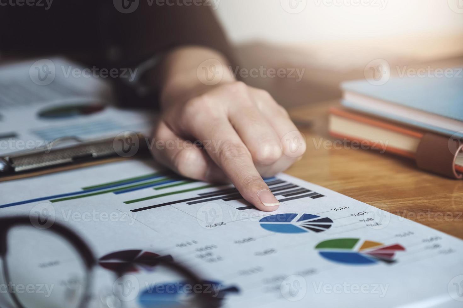 mujer de negocios apuntando a gráficos que muestran el mercado de inversión foto