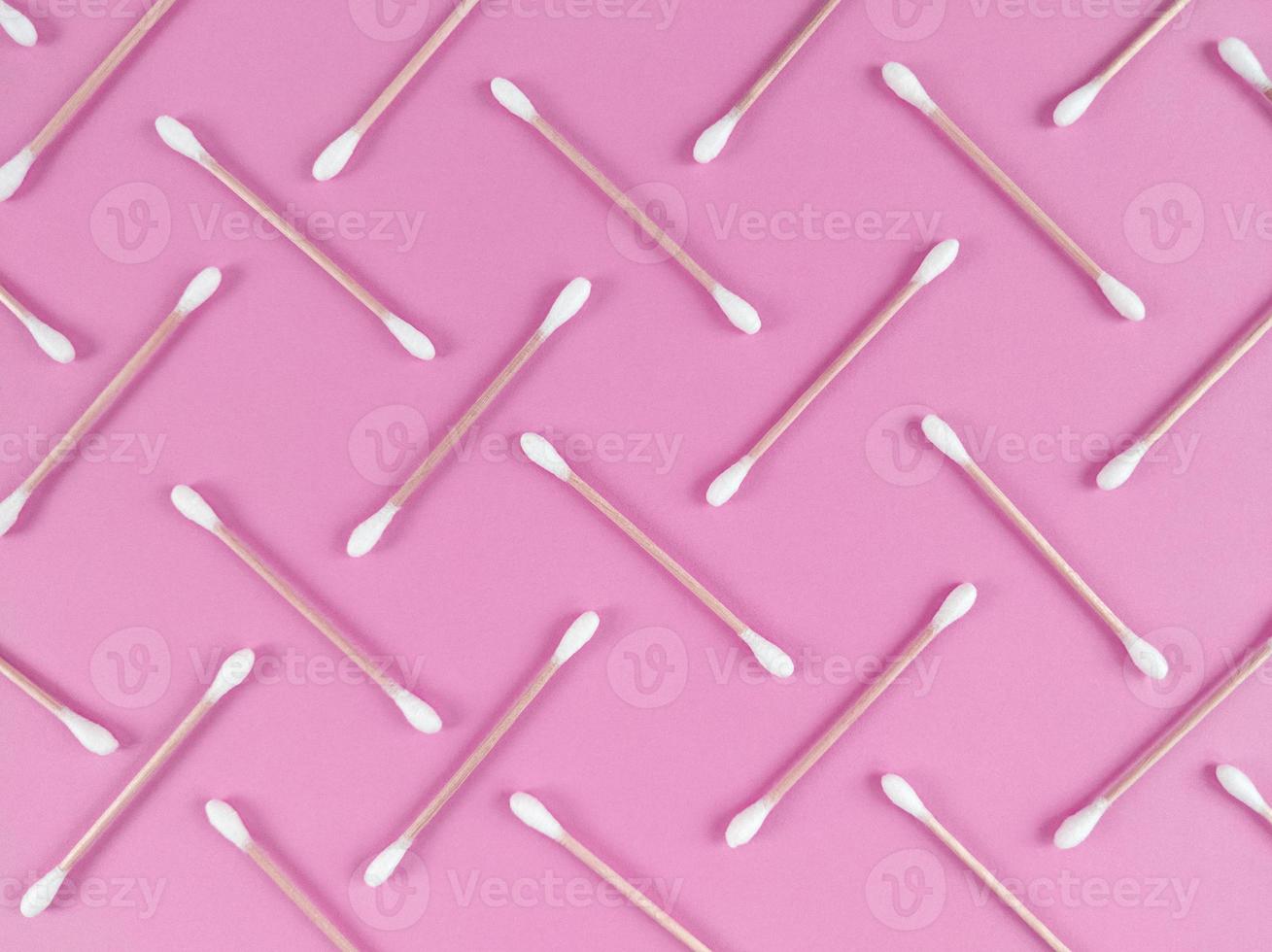Patrón hecho de bastoncillos de algodón de bambú sobre fondo rosa foto