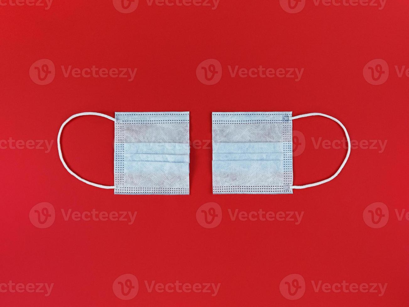 Medical disposable face mask cut in half on red background photo