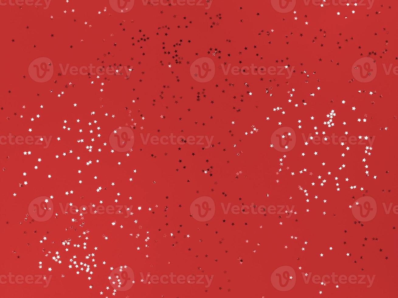 Confetti stars on a red paper Festive background photo