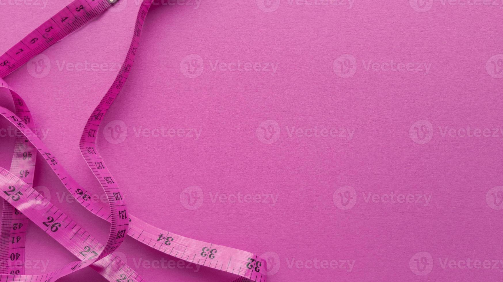 Pink centimeter on pink background Simple flat lay with pastel texture Fitness concept Stock photo