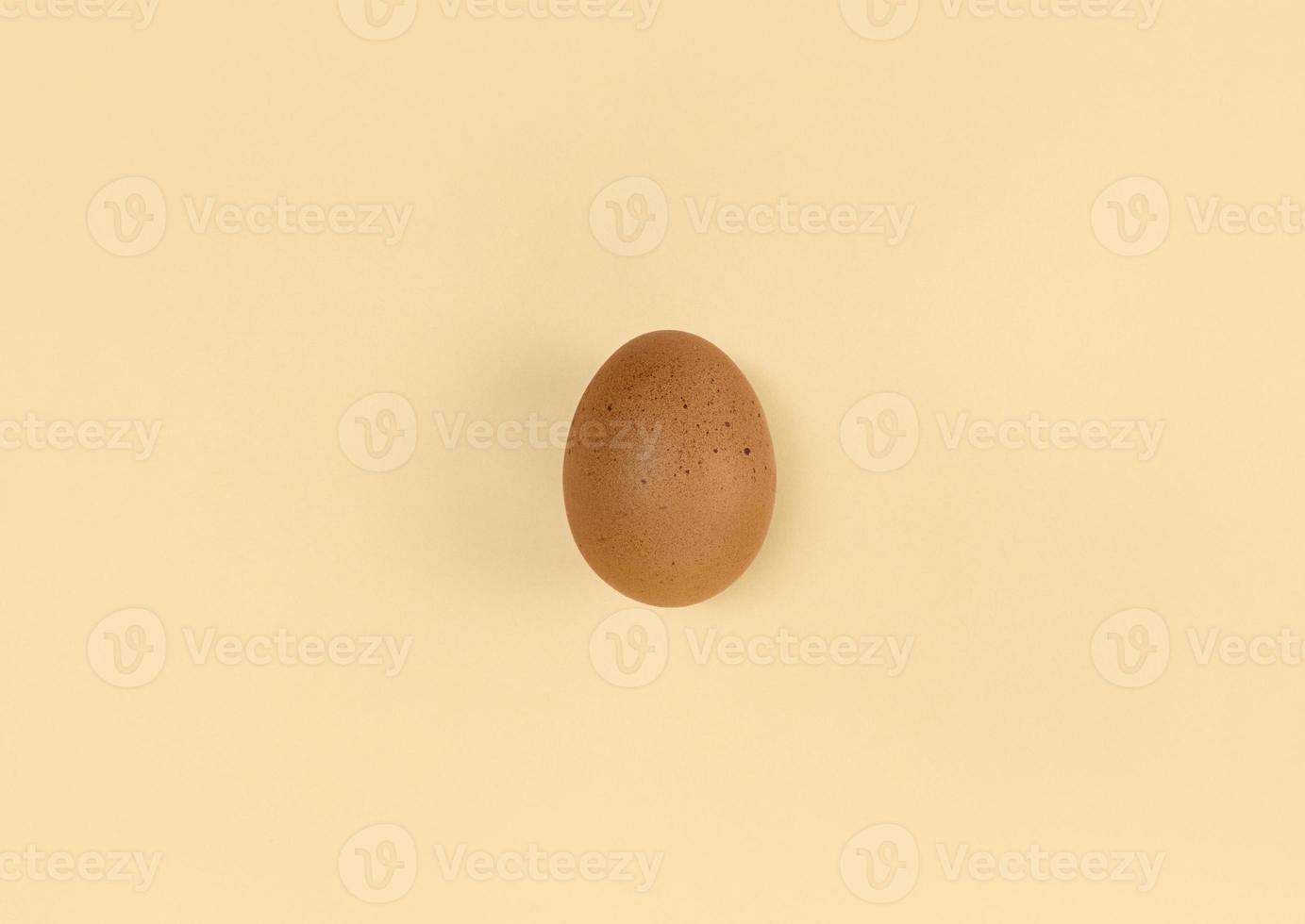 Brown egg on beige backdrop Minimalist flat lay photo