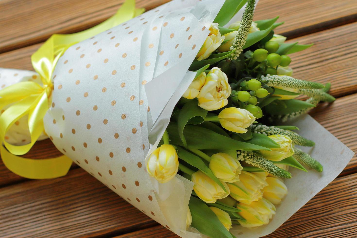 ramo de tulipanes amarillos en paquete blanco y tira foto