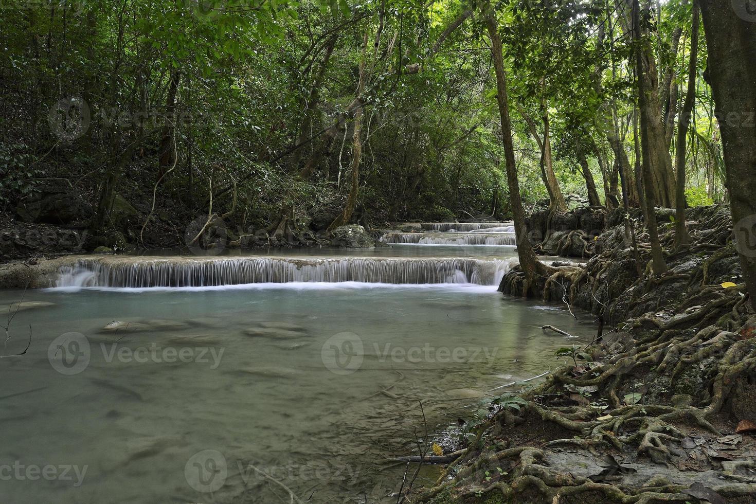 Beautiful waterfalls of turquoise water in the middle of the jungle in Thailand photo