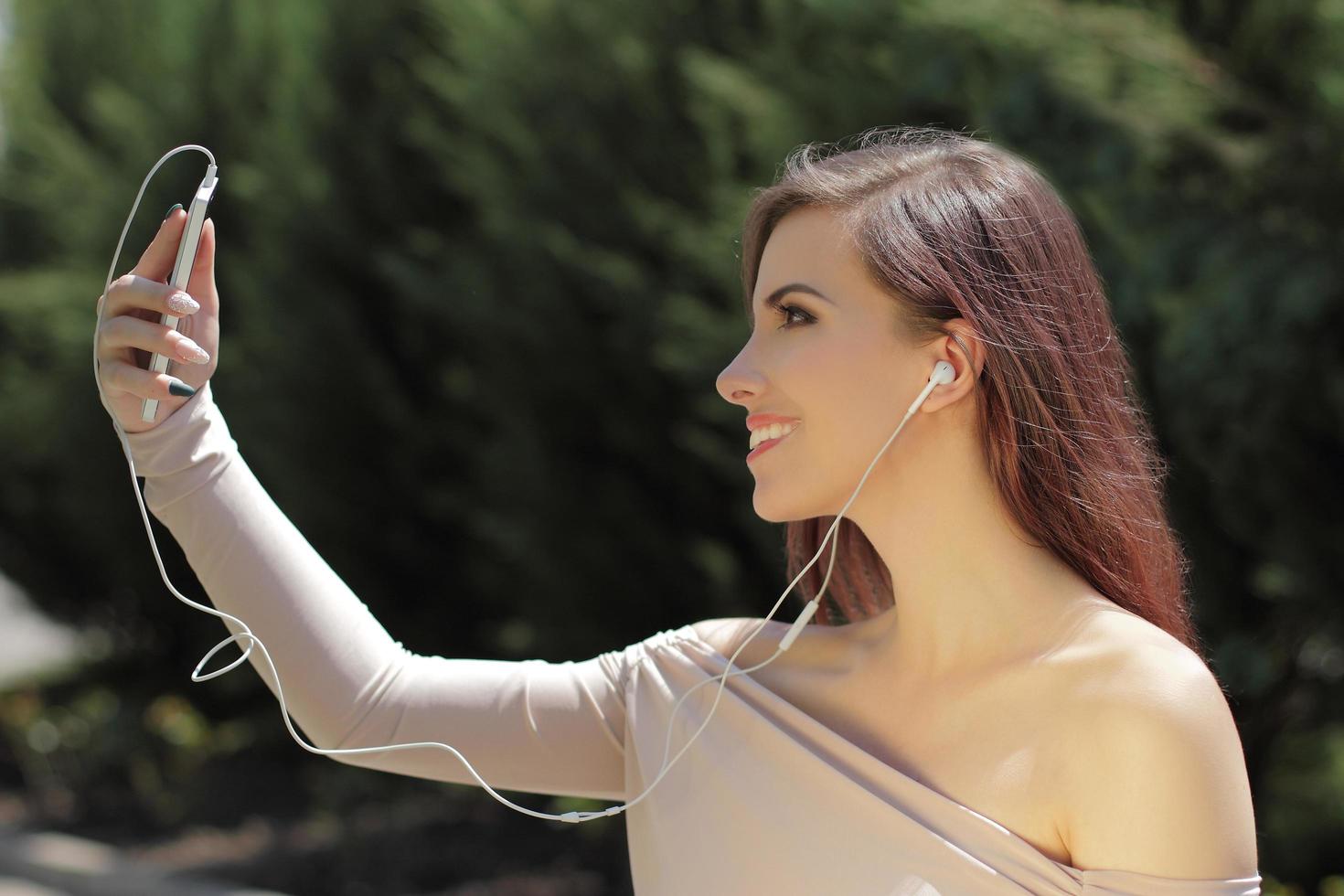 niña sonriente escuchando música en el teléfono móvil foto