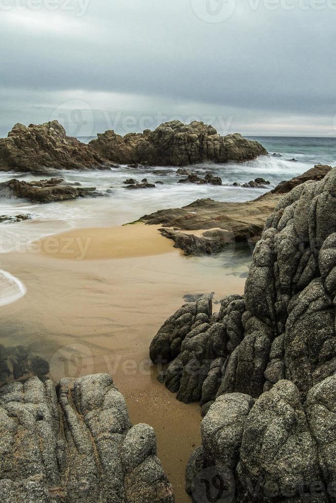 paisaje marino nublado en una playa rocosa foto